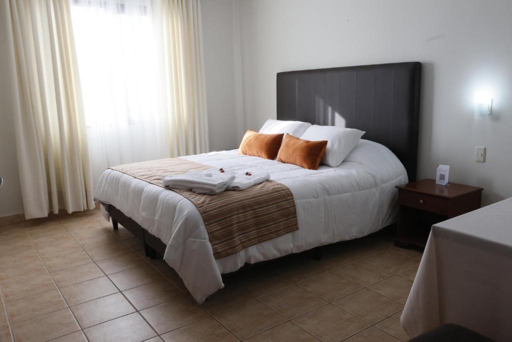 苏克雷Hotel Qhawarina de Casas Kolping Bolivia S.R.L.的一间卧室配有一张大床和两个枕头