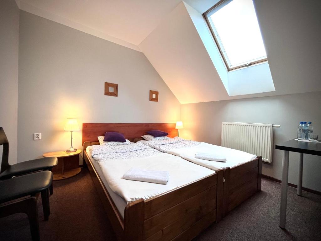 弗热希尼亚隆多宾馆的一间卧室配有一张带天窗的大床