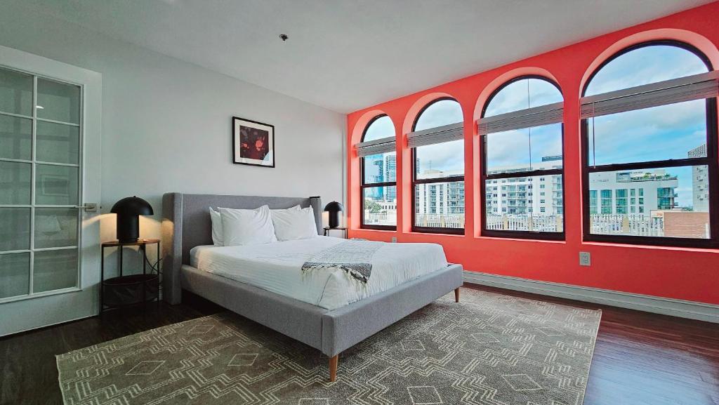 西棕榈滩The Lofts on Clematis 503 Downtown West Palm Beach的一间卧室设有一张带红色墙壁和窗户的床。