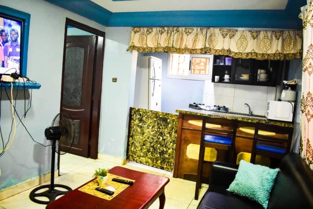 班基Appartement/Studio meublé a Bangui的一间带桌子的客厅和一间厨房