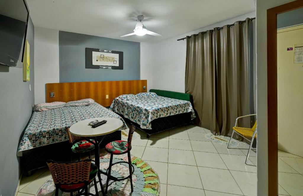 卡达斯诺瓦斯Condominio Residencial Thermas Place的一间卧室配有两张床和一张桌子及椅子