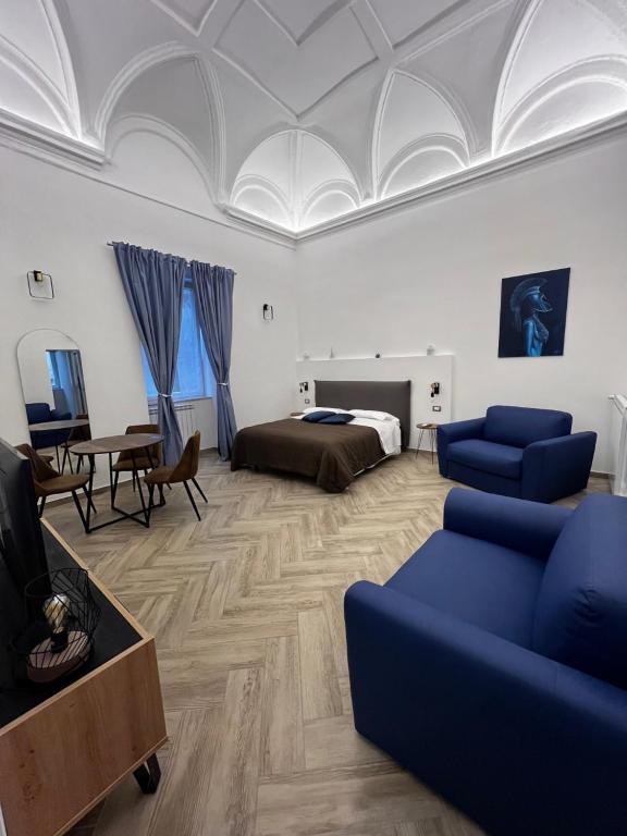 那不勒斯Dimora Dei Decumani的一间卧室配有一张床、一张沙发和一张桌子