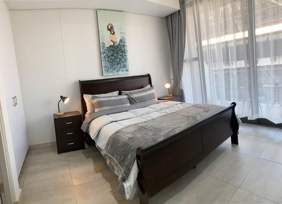 约翰内斯堡Modern Exec 2Bed Apartment at Infinite的一间卧室设有一张大床和一个窗户。