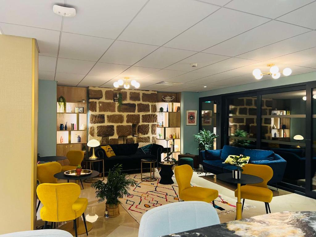 布里夫拉盖亚尔德Hotel Le Quercy - Sure Hotel Collection by Best Western的客厅配有黄色椅子和蓝色沙发