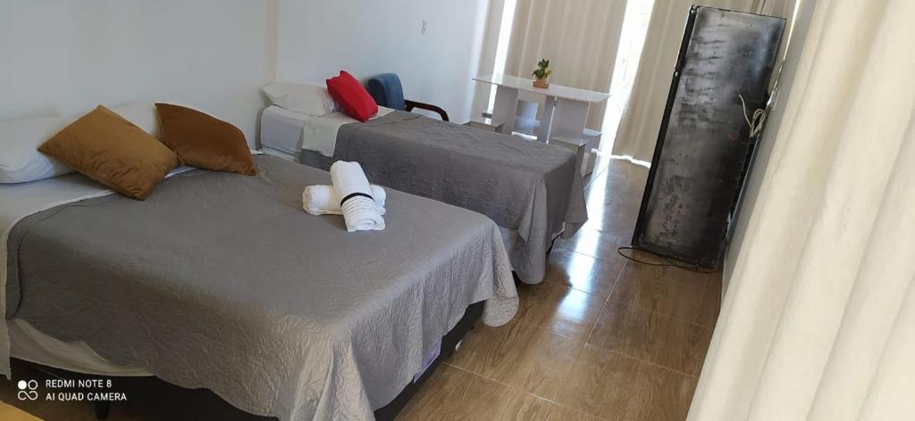 巴伊亚福尔莫萨Quarto Família - Com Suíte的一间客房配有两张床和一张沙发