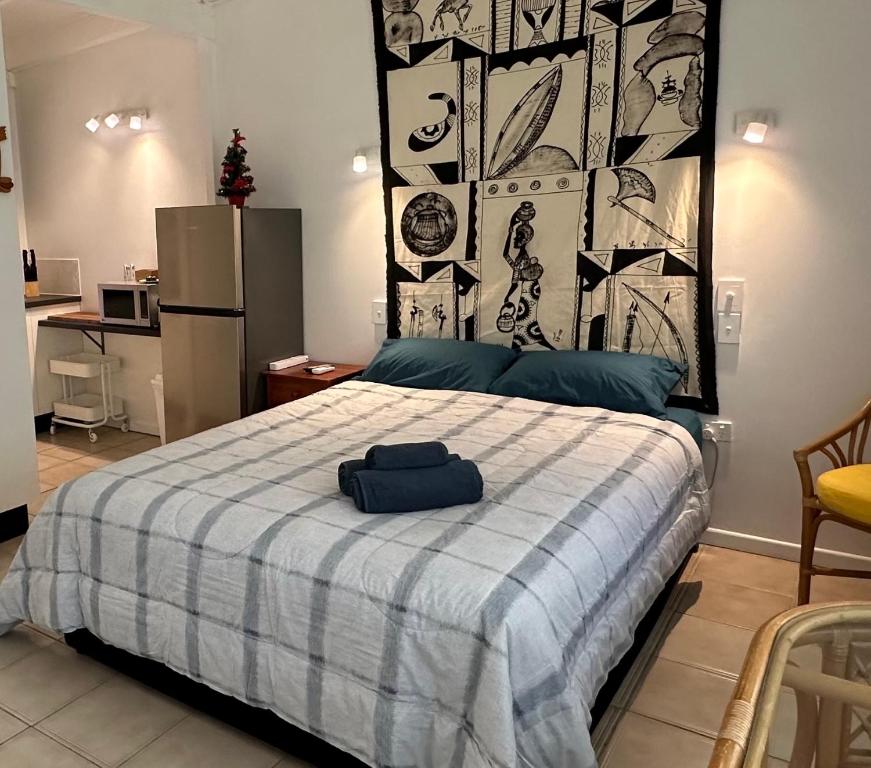 耐莉湾Magnetic Island Resort Studio的一间卧室配有一张带蓝白色毯子的床