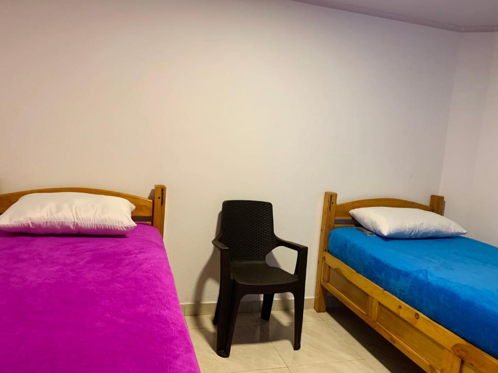 波哥大Hostel Bogotá Kings的一间设有两张床和椅子的房间