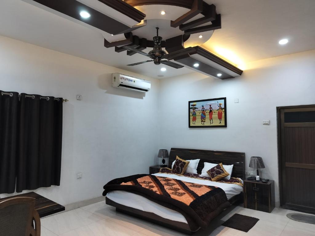 Pura RaghunāthHotel Dawat的一间卧室配有一张床和吊扇