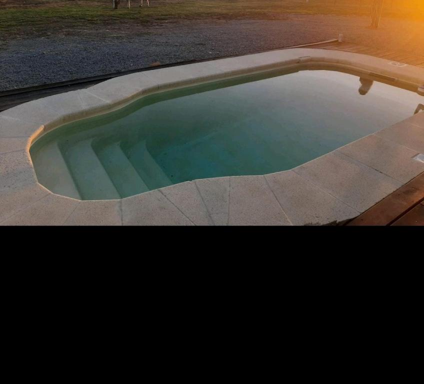 特立尼达岛Casa de Campo acogedora的一座小游泳池,位于庭院内,享有日落美景