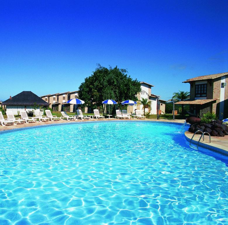 皮帕瓦兰达斯月德琵琶酒店的游泳池,酒店配有椅子和遮阳伞