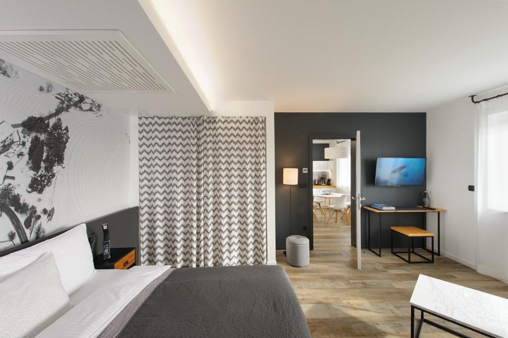马里博尔Apartments CityMap Maribor-Free parking!的一间卧室配有一张床、一张书桌和一台电视