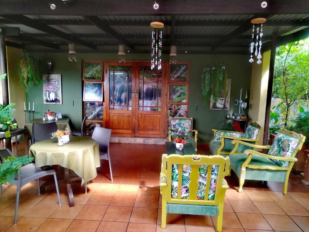 纳布姆斯普雷特Africas Eden Guesthouse的一间带椅子和桌子的房间以及一扇门