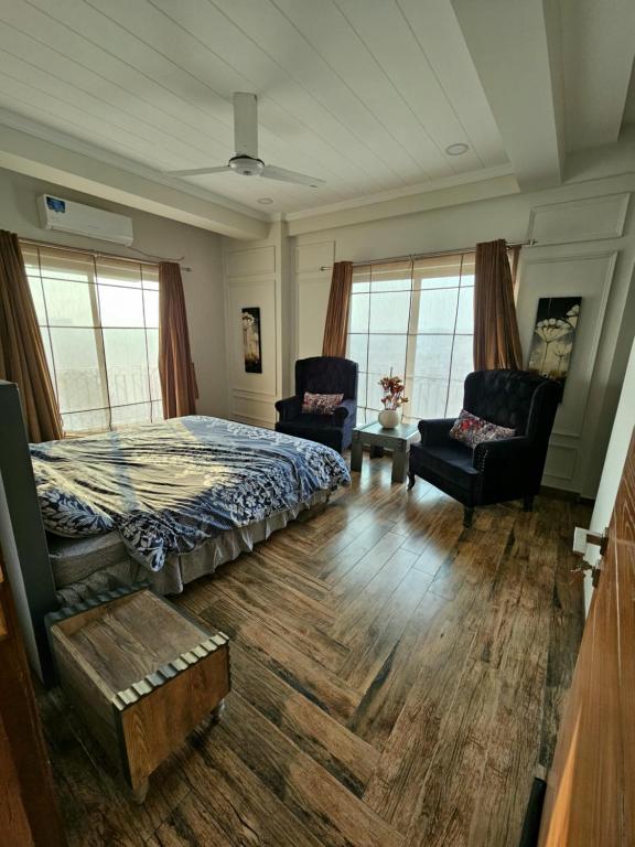 拉瓦尔品第Aesthetic Scenic Luxurious Apartment - Bahria Heights的一间卧室配有一张床、一张沙发和椅子