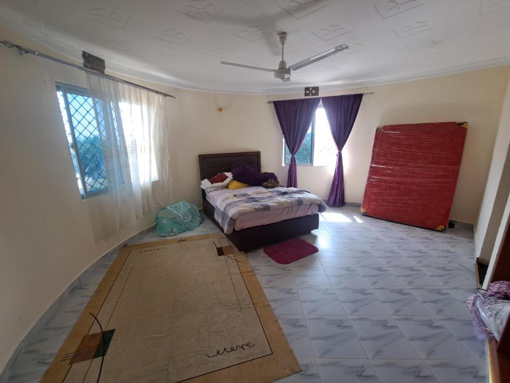 乌昆达Diamond Sands Villa的卧室配有一张床和地板上的纸箱