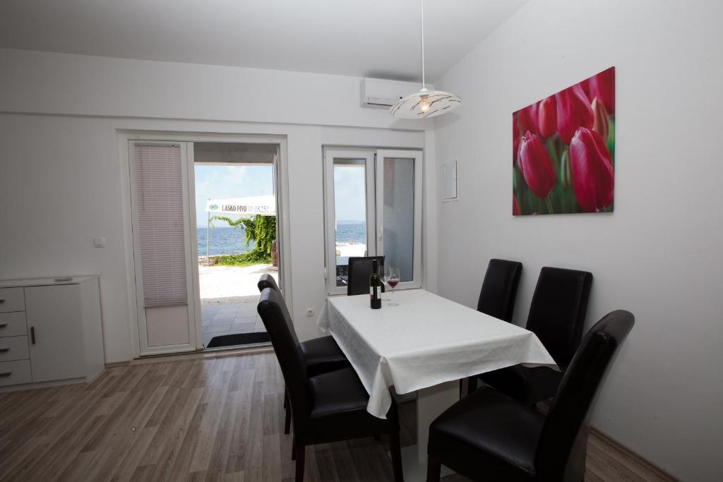 珀德垂那Beach Apartments Dora的用餐室配有桌椅和绘画作品