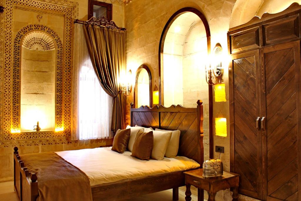 马尔丁HH Babil Konağı的一间带一张床铺的卧室,位于带拱门的房间