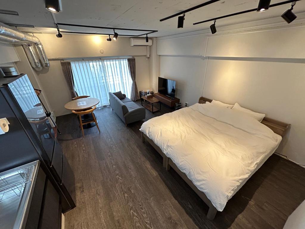 东京NIYS apartments 37 type的一间卧室配有一张床、一把椅子和一张桌子