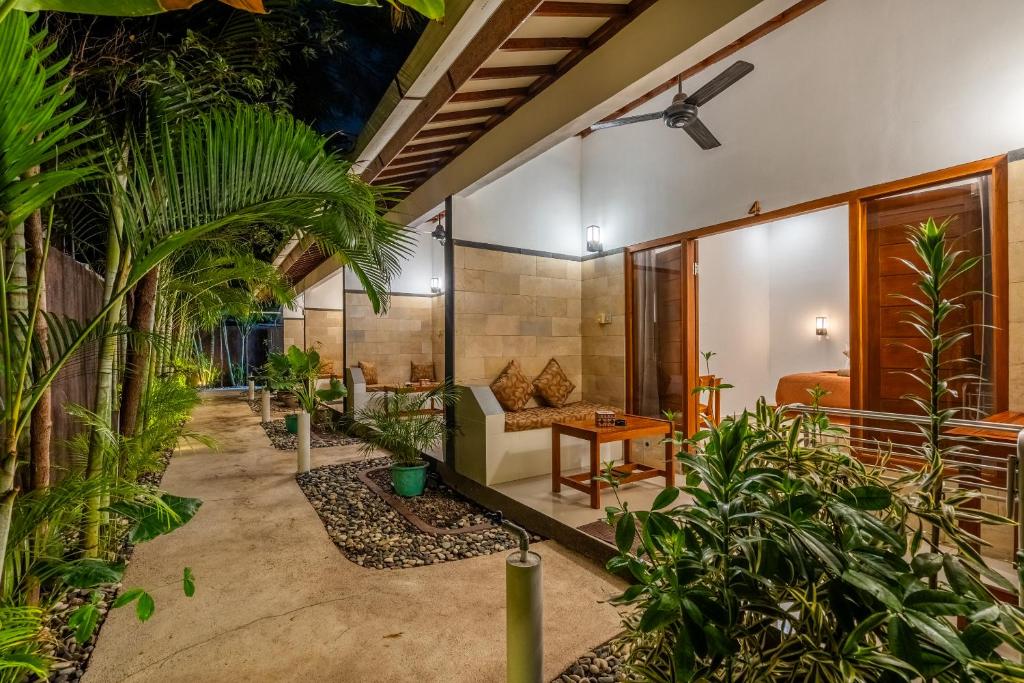 吉利阿尔Villa Doria formerly Rangga Homestay的客厅里种有植物,配有沙发