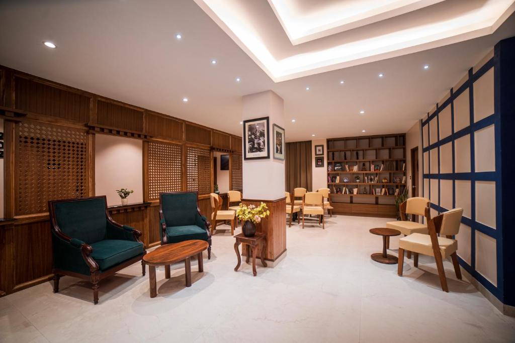 甘托克Zip By Spree Hotels Gangtok的图书馆配有椅子、桌子和书籍