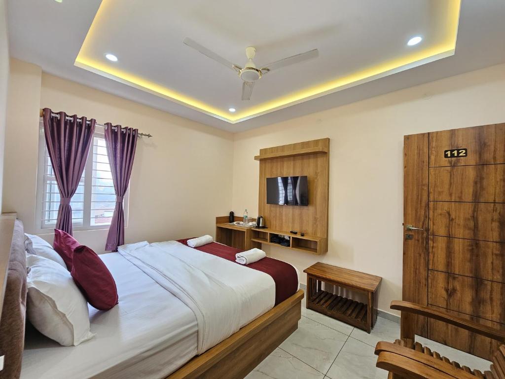 马迪凯里Navarathna Comforts的一间带大床和电视的卧室