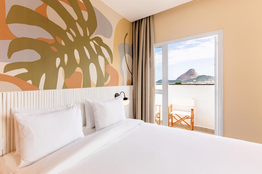 里约热内卢B&B HOTEL Santos Dumont的一间卧室设有一张大床,享有海景