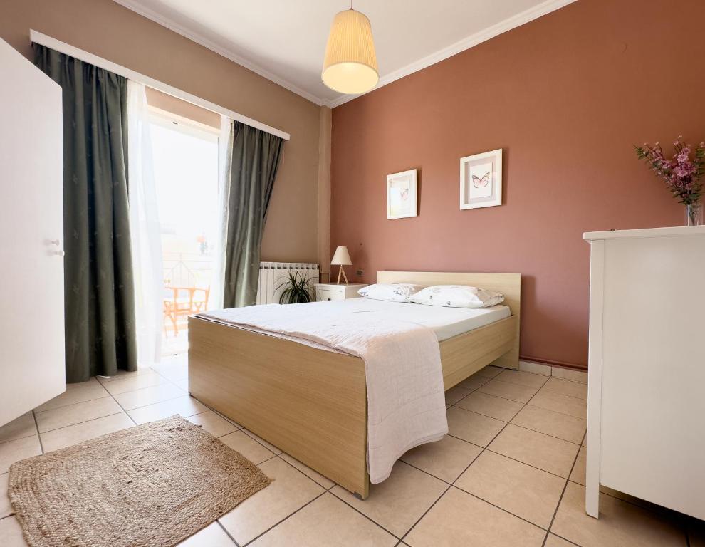 拉夫里翁Spacious & Bright flat with balcony的一间卧室设有一张床和一个大窗户