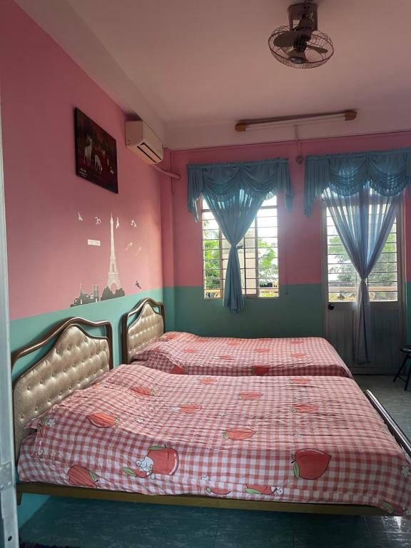 河仙Huỳnh Hương Guesthouse的粉红色墙壁和窗户的客房内的一张床位