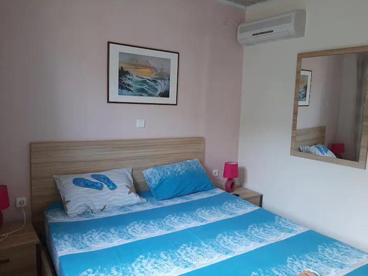 Ágios KonstantínosChristina Apartment的一间卧室配有一张带蓝色床单和镜子的床