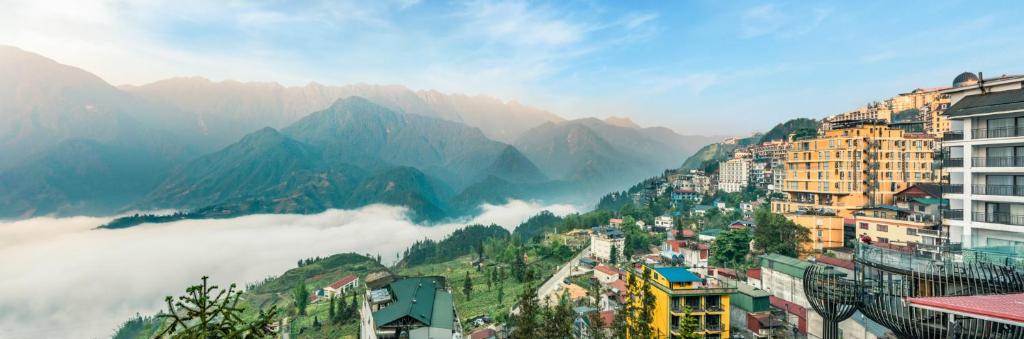 萨帕Tiger Sapa hotel的享有以山脉为背景的城市美景