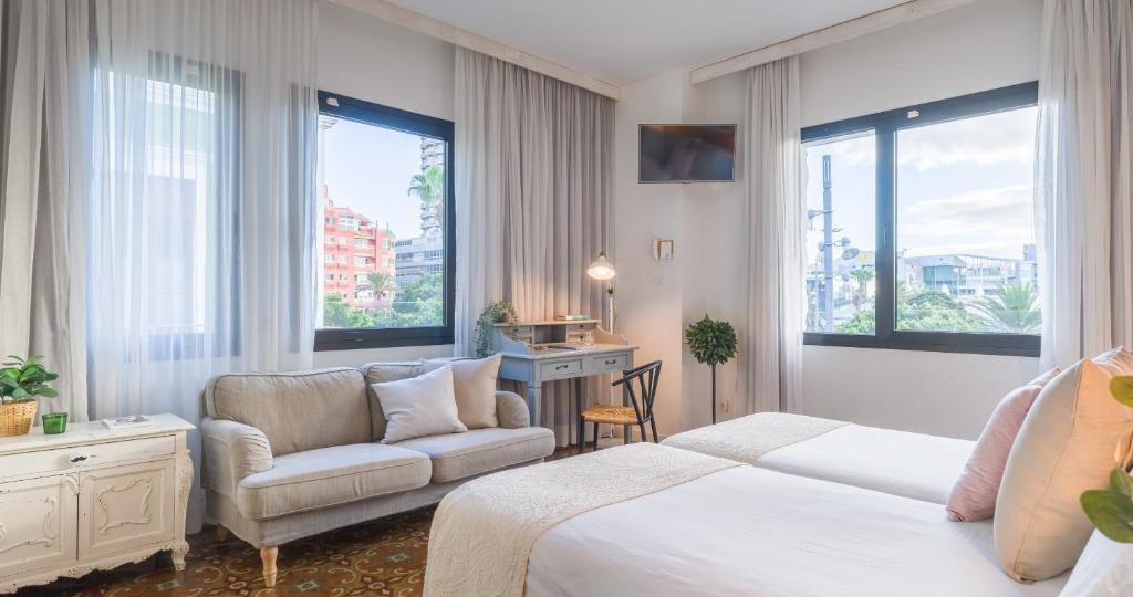 大加那利岛拉斯帕尔马斯Bed and Chic的酒店客房带一张床、椅子和窗户