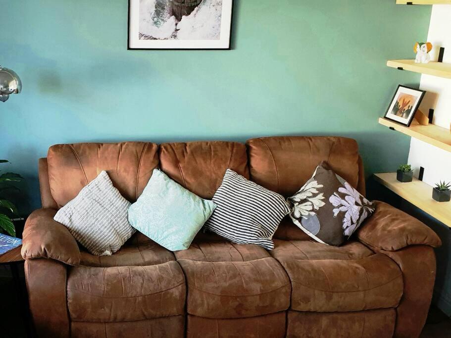 诺丁汉Entire house in Sherwood, Nottingham的客厅里配有带枕头的棕色沙发