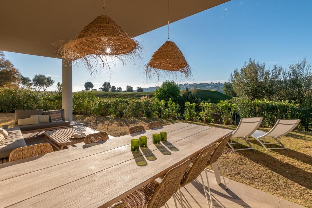 米哈斯科斯塔Chic 3BR Haven - Luxury Ground Floor - La Cala Golf的一张木桌和椅子,享有田野的景色