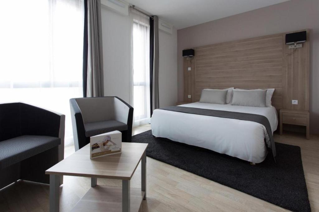 阿斯克新城Twenty Business Flats Lille Grand Stade的一间卧室配有一张床、一把椅子和一张桌子