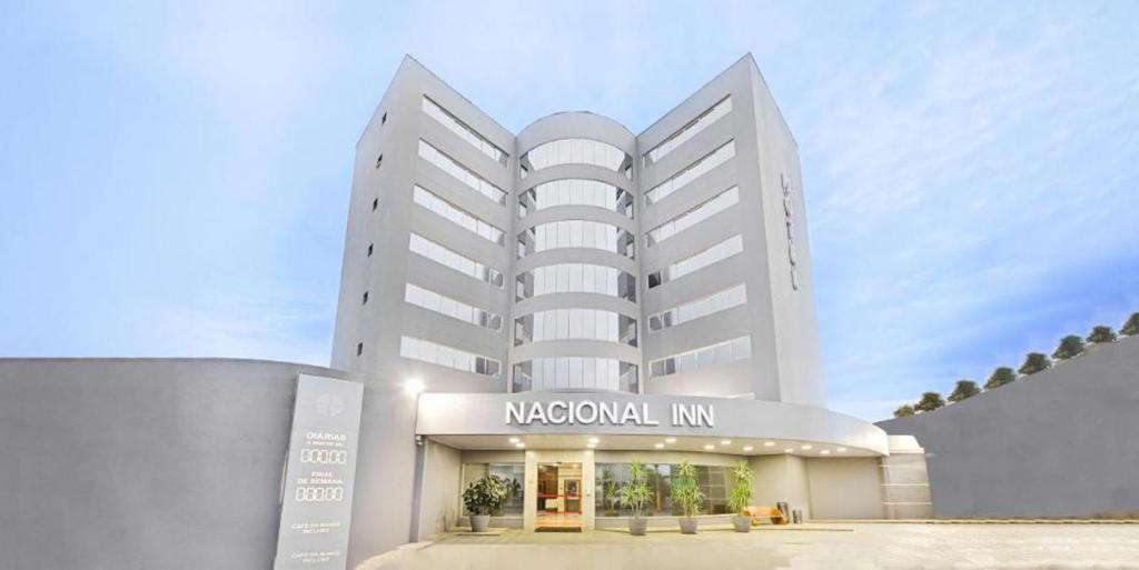 库亚巴Hotel Nacional Inn Cuiabá的一座白色的大建筑,上面标有读区旅馆