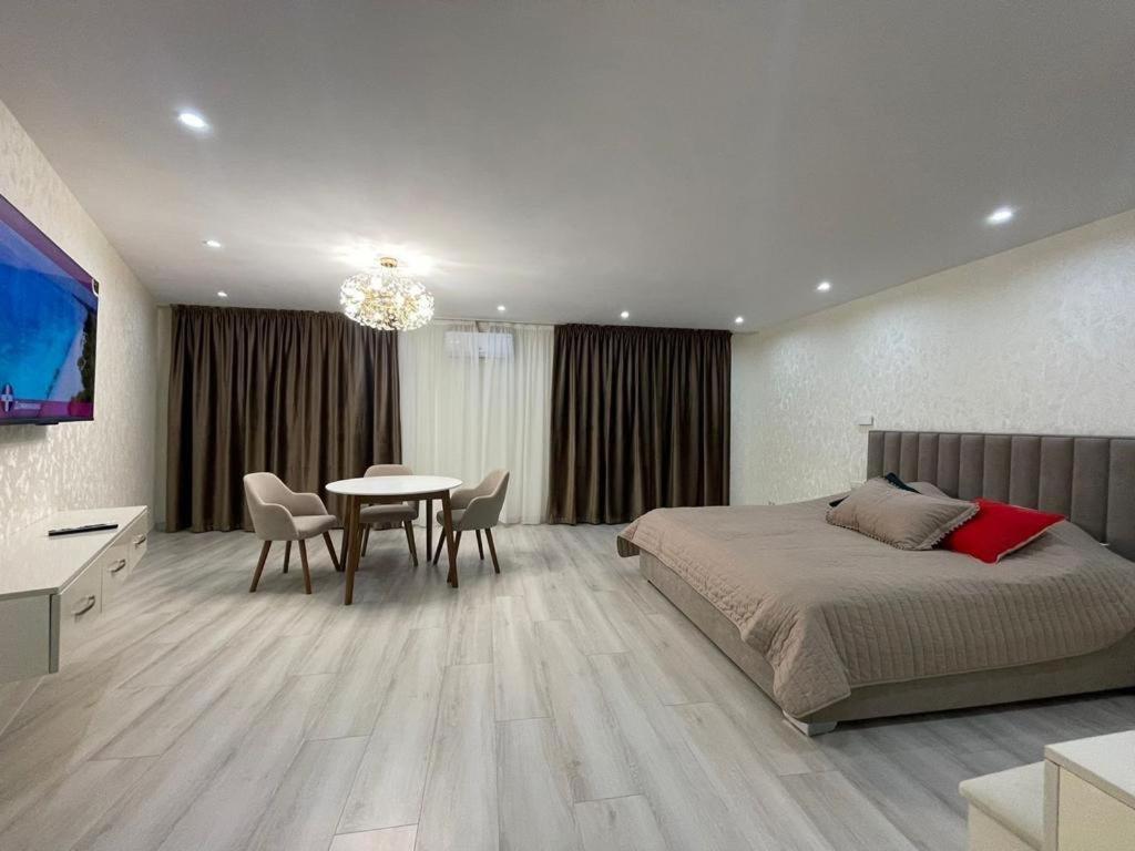 撒马尔罕Samarkand Central Apartments的一间卧室配有一张床和一张桌子及椅子