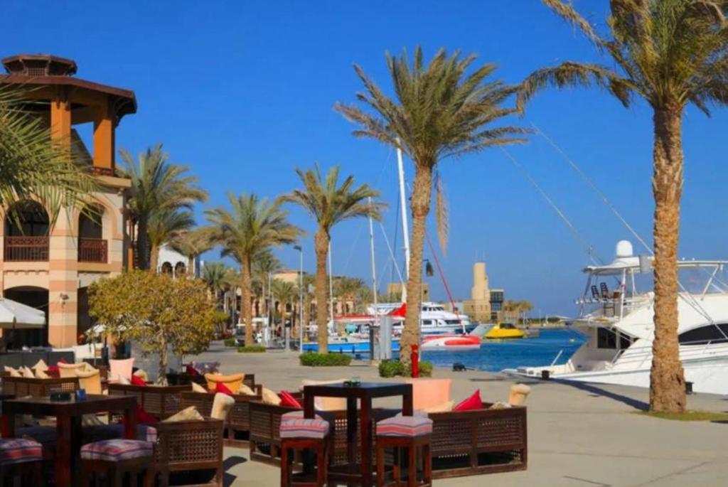 加利布港FeWo Port Ghalib的棕榈树和桌子的度假村和船只