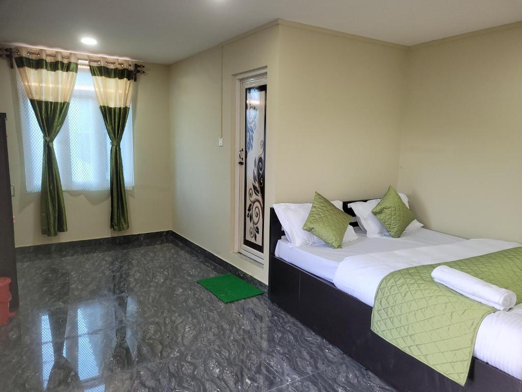 西隆Vati guesthouse的一间卧室设有两张床和窗户。