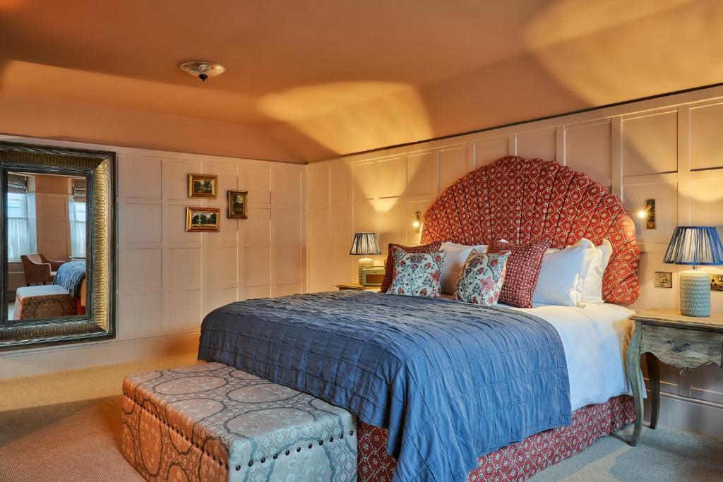 多尔金The White Horse的一间卧室设有一张大床和一个大镜子