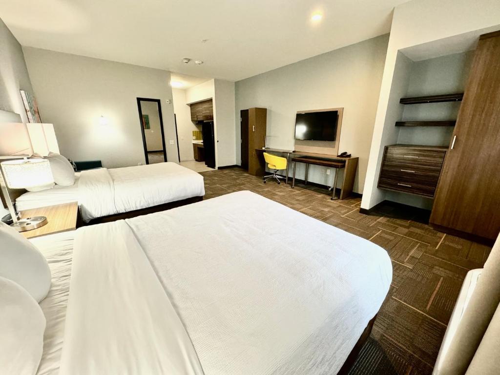 斯托克顿堡Fort Stockton Inn and Suites的酒店客房设有两张床和电视。