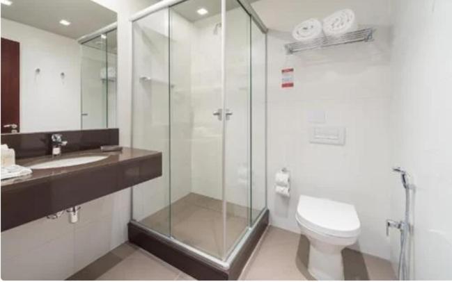 格拉玛多Hotel Laghetto Stilo Borges的一间带玻璃淋浴和卫生间的浴室