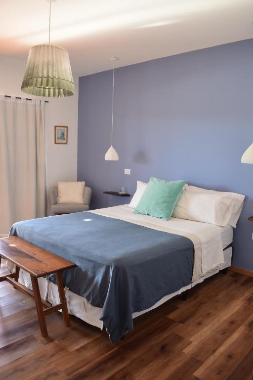 卢汉德库约Villa Mendotza的一间卧室配有一张带蓝色毯子的大床