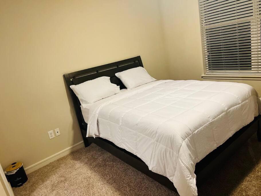 休斯顿Home at Energy corridor的卧室内的一张带白色床单和枕头的床