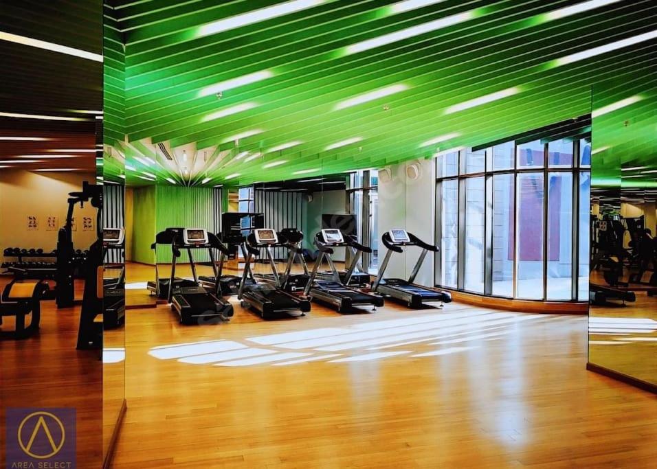 伊斯坦布尔Merkezi, havuzlu, lüx site içerisinde komförlü homeoffice的一间健身房,拥有数台跑步机和绿色天花板