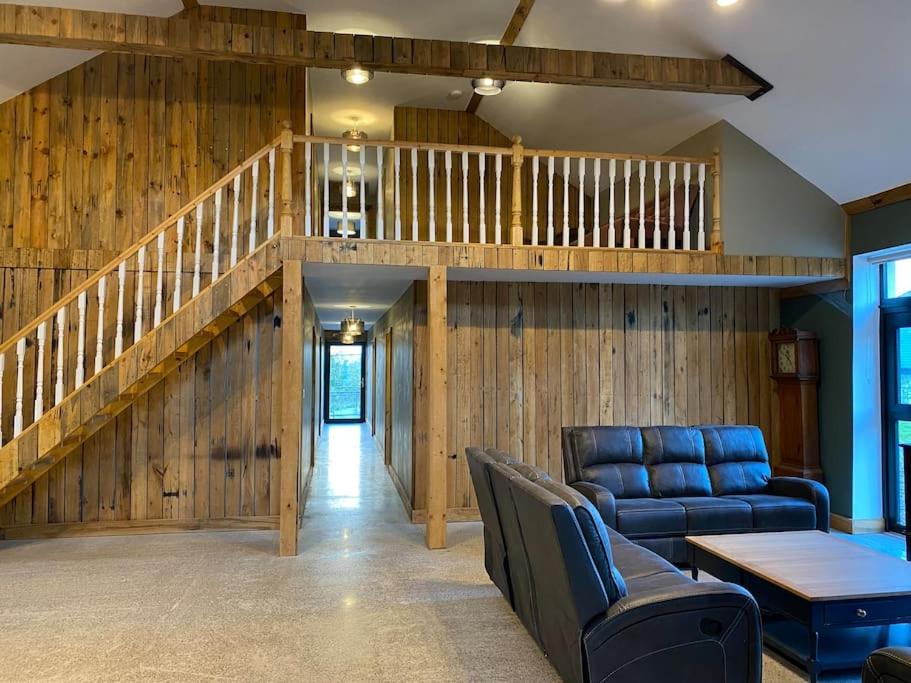 利默里克Moig Lodge - 7 Double Bedroom Barn Conversion的带沙发和楼梯的客厅