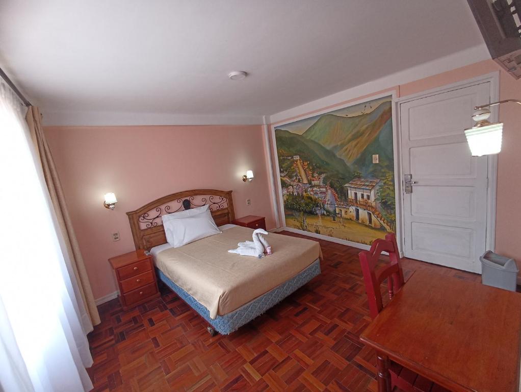 拉巴斯RIXAA Hotels的卧室配有一张床,墙上挂有绘画作品