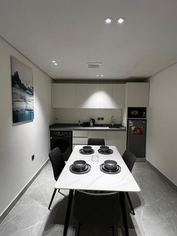 利雅德الحزم للشقق الفندقية - الرياض - العليا的厨房配有白色的桌椅