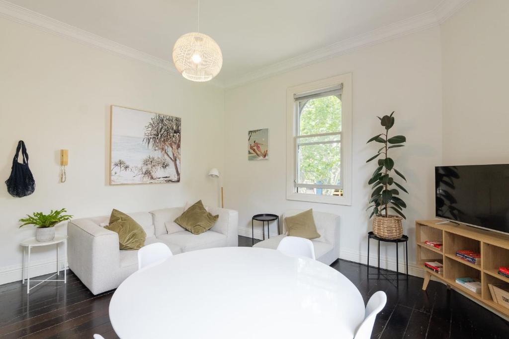 悉尼Surry Hills Chic right on Crown St的客厅配有白色家具和平面电视