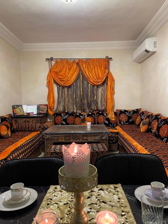 马拉喀什Kech Days appartement près de l'aéroport的带沙发和一张带蜡烛的桌子的客厅