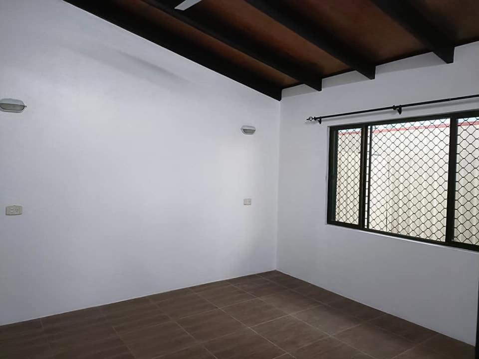 南迪Balabala Bed & Breakfast的一间空房间,有窗户和白色的墙壁