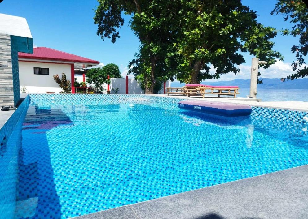 MalitbogPortofino Homestay的蓝色的游泳池,享有水景